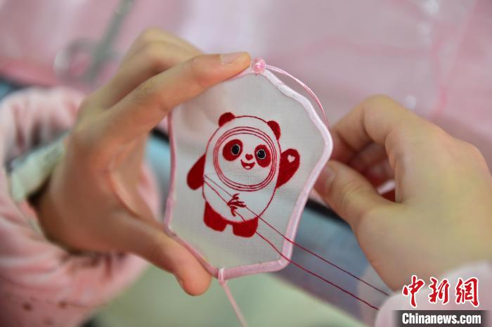 圖為一名小學(xué)生正在繡制2022年北京冬奧會(huì)吉祥物“冰墩墩”形象。　喻云亮 攝