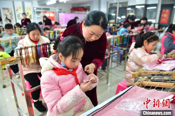 江西省級(jí)非遺豫章繡傳承人手把手指導(dǎo)小學(xué)生繡制2022年北京冬奧會(huì)吉祥物“冰墩墩”形象?！∮髟屏?攝