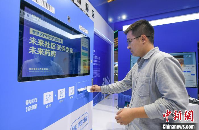 在“中國醫(yī)保 一生守護(hù)”展區(qū)，民眾體驗在24小時未來藥房憑“處方”取藥 王剛 攝
