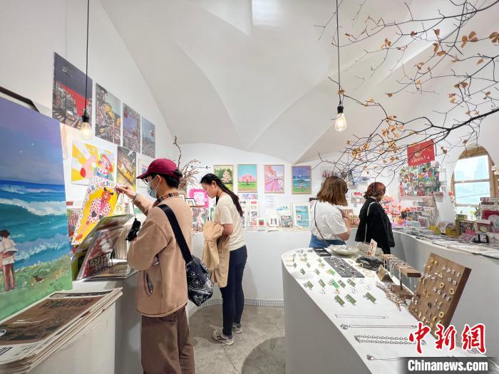圖為藝術(shù)品商店內(nèi)，顧客挑選插畫(huà)作品?！＄婌?攝
