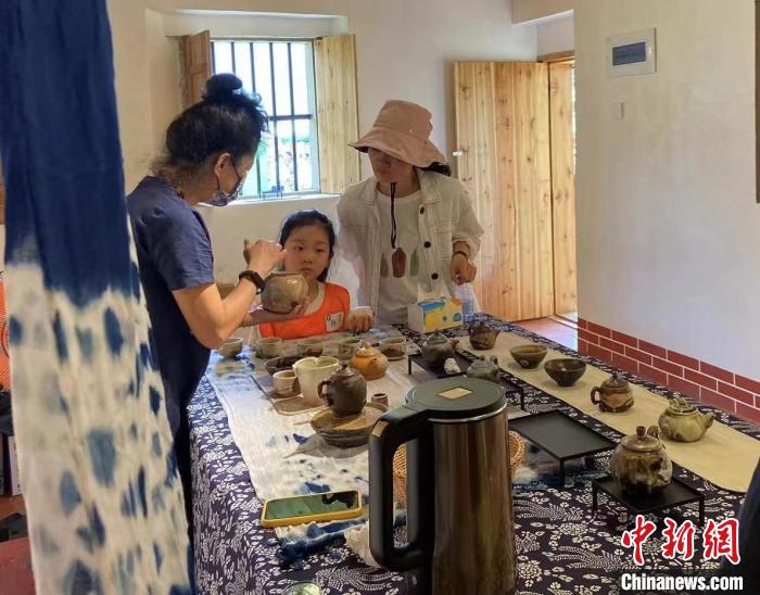 圖為：游客正在咨詢臺灣柴燒作品?！∪~秋云 攝