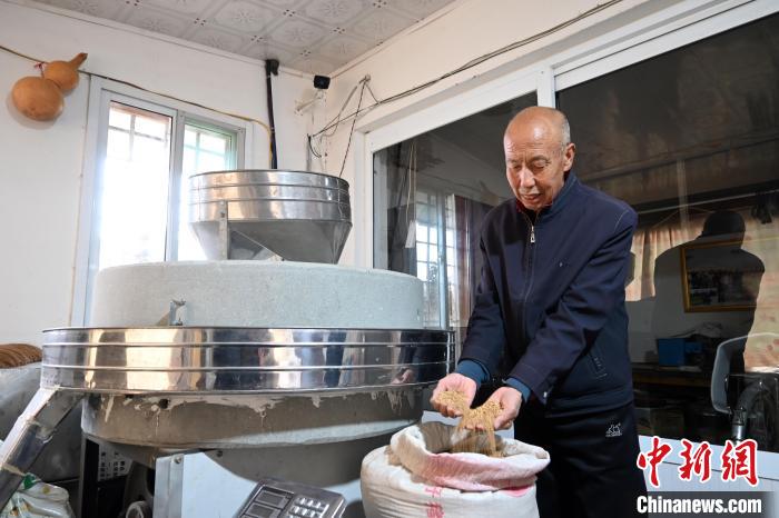 李家莊村民谷文朝重拾父輩的手藝，做起石磨面粉的營生?！〉杂鸺?攝