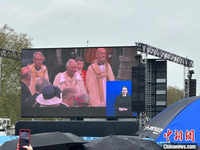 當(dāng)?shù)貢r間5月6日，英國國王查爾斯三世的加冕儀式舉行。民眾雨中觀看儀式。　歐陽開宇 攝