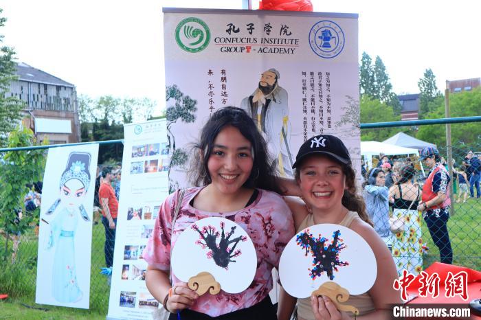 孩子們展示自己的吹墨畫團(tuán)扇作品?！◆斻肟鬃訉W(xué)院供圖