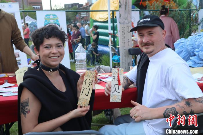 當(dāng)?shù)孛癖娫跐h字體驗(yàn)工作坊展示自己手寫的中文名書簽?！◆斻肟鬃訉W(xué)院供圖