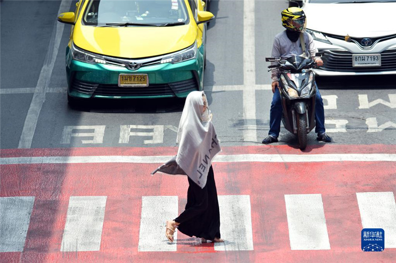 5月17日，行人在泰國曼谷街頭用圍巾遮陽。新華社發(fā)（拉亨攝）