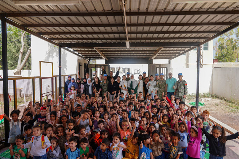 當(dāng)?shù)貢r(shí)間5月30日，黎巴嫩南部庫雷拉公立小學(xué)，“六一”國際兒童節(jié)前夕，中國第21批赴黎維和多功能工兵分隊(duì)官兵看望慰問學(xué)校師生，并開展文化交流活動(dòng)，圖為我維和官兵同師生合影。李竹林?jǐn)z