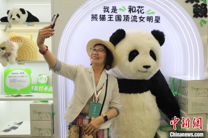 美國華視總裁楊蓮花與大熊貓文創(chuàng)產(chǎn)品合影?！⊥趵?攝