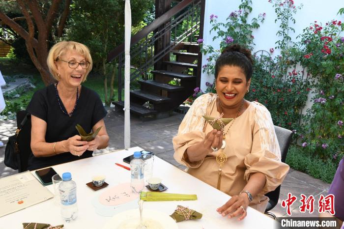 圖為嘉賓展示包粽子成果?！“亓种袊幕行墓﹫D。