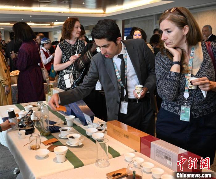 現(xiàn)場(chǎng)觀眾觀看中國(guó)展臺(tái)茶藝表演、了解茶文化。　靖樹 攝