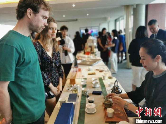 現(xiàn)場(chǎng)觀眾觀看中國(guó)展臺(tái)茶藝表演、了解茶文化。　靖樹 攝