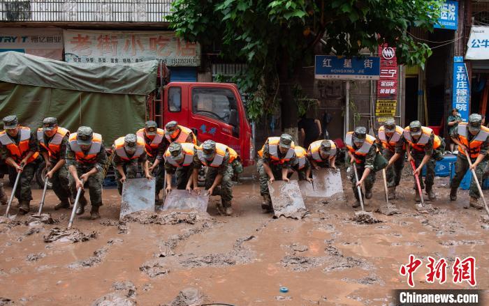 7月4日，萬州區(qū)五橋街道，武警官兵清理街道上的淤泥?！∪矫宪?攝