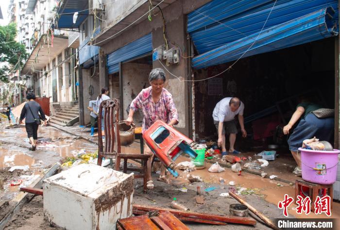 7月4日，萬州區(qū)五橋街道，洪水退去后，居民搶救生活物資?！∪矫宪?攝