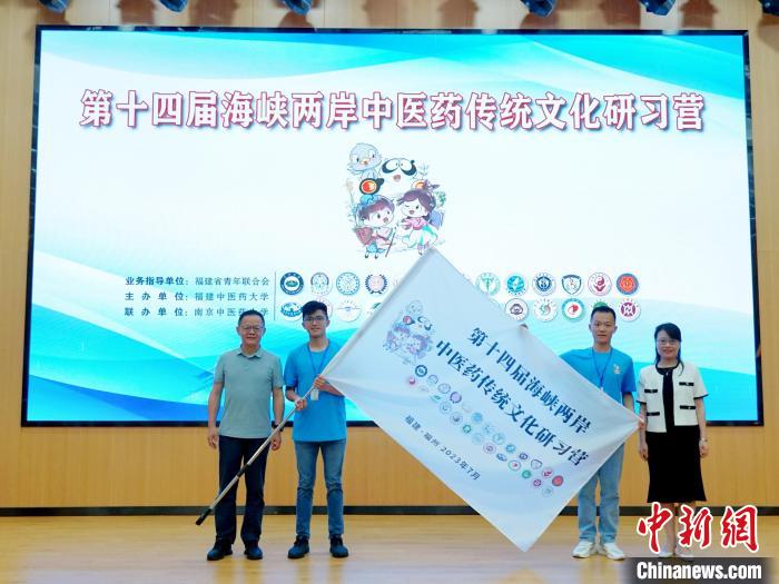 共青團(tuán)福建省委副書記吳雪(右一)、福建中醫(yī)藥大學(xué)黨委副書記林羽(左一)為兩岸學(xué)生代表頒授營(yíng)旗?！≡S燁婷 攝