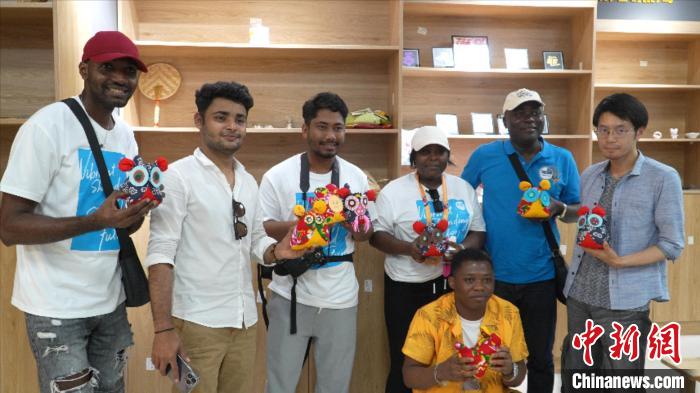 圖為國際青年代表展示親手制作的東營非遺黃河口布偶 ?！↓R魯 攝