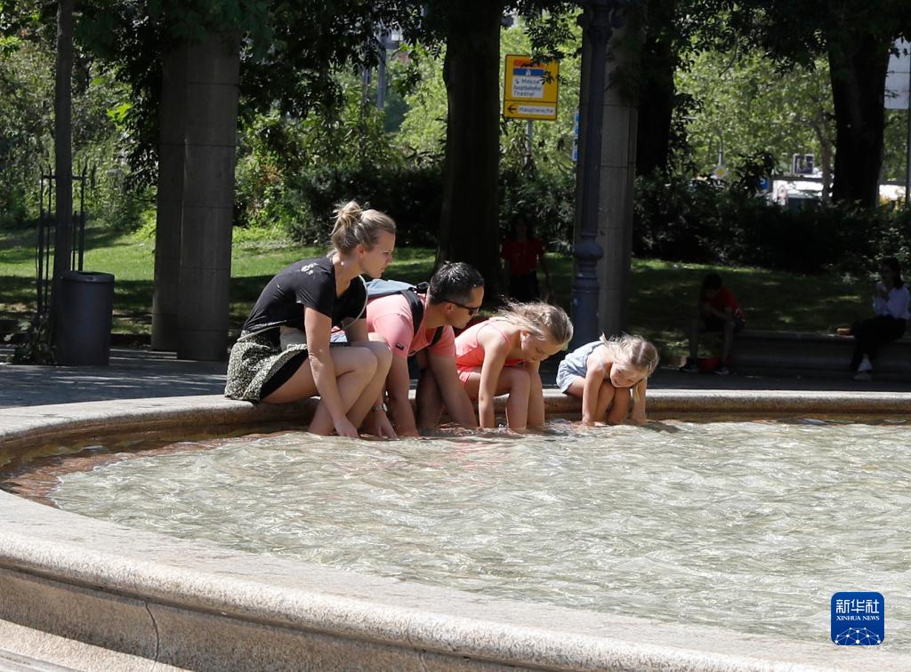 7月8日，人們在德國法蘭克福的一處噴泉玩水。近日，德國法蘭克福逐漸迎來暑熱天氣。新華社記者 張帆 攝