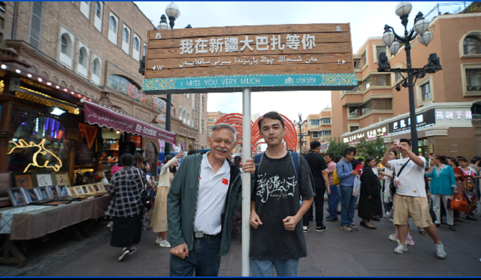 潘維廉和維吾爾族青年伊木蘭“打卡”大巴扎。主辦方供圖