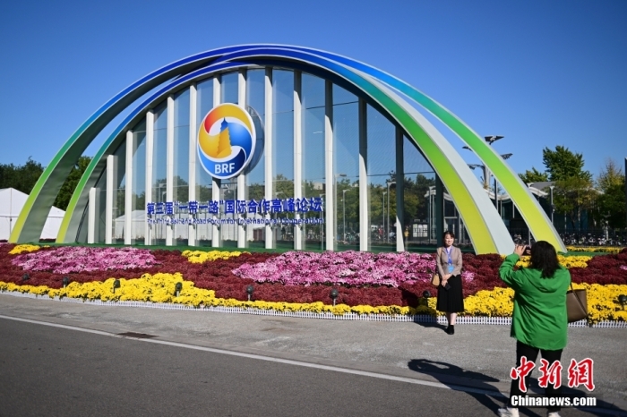 10月15日，北京，工作人員在國家會議中心外的第三屆“一帶一路”國際合作高峰論壇景觀布置前拍照留念。當(dāng)日，位于國家會議中心的第三屆“一帶一路”國際合作高峰論壇新聞中心啟動試運行。據(jù)悉，第三屆“一帶一路”國際合作高峰論壇將于10月17日至18日在北京舉行。<a target='_blank' href='/'><p  align=