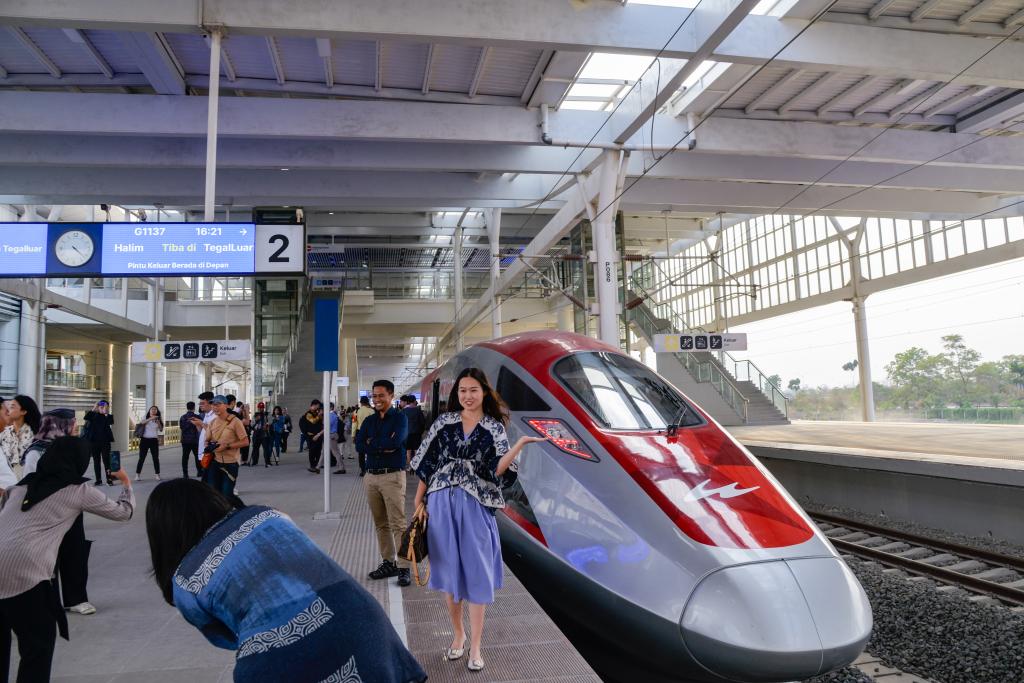 10月17日，在印度尼西亞萬隆德卡魯爾站，乘客在站臺上和雅萬高鐵高速動車組列車合影。