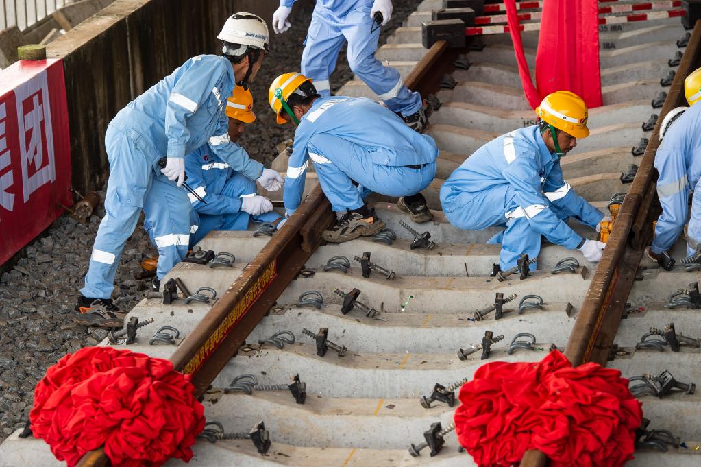 3月31日，在印度尼西亞雅加達雅萬高鐵哈利姆車站，工人鋪設(shè)雅萬高鐵全線最后一根鋼軌。