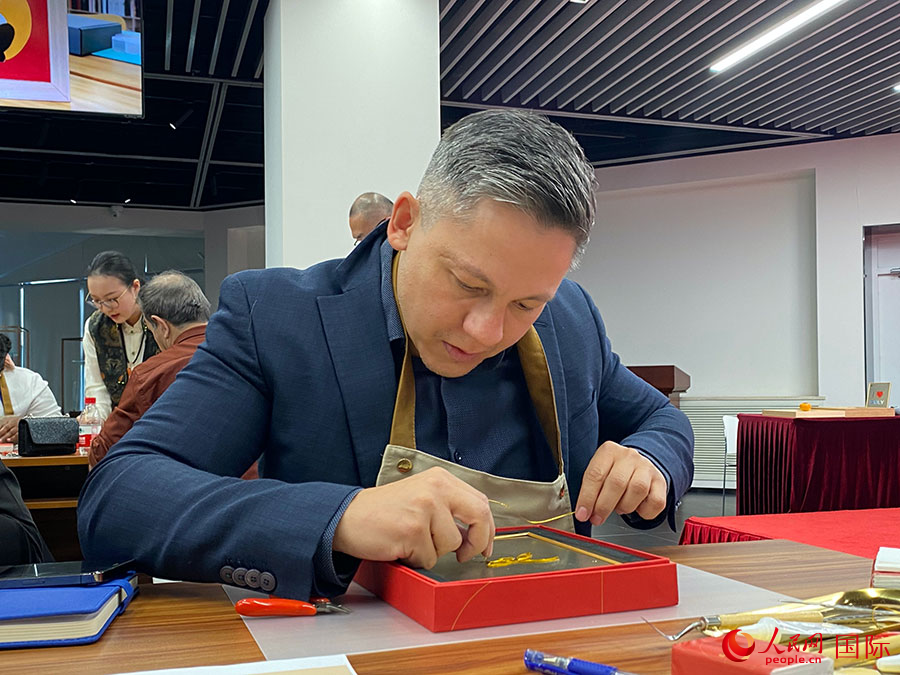 2023“一帶一路”媒體合作論壇聯(lián)合采訪團團員，親身體驗景泰藍工藝。人民網記者 于洋攝