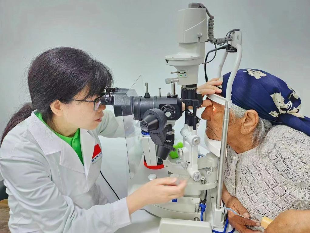 北京大學(xué)人民醫(yī)院眼科醫(yī)生鮑永珍正在為中亞白內(nèi)障患者進(jìn)行眼部檢查。（北京大學(xué)人民醫(yī)院供圖）