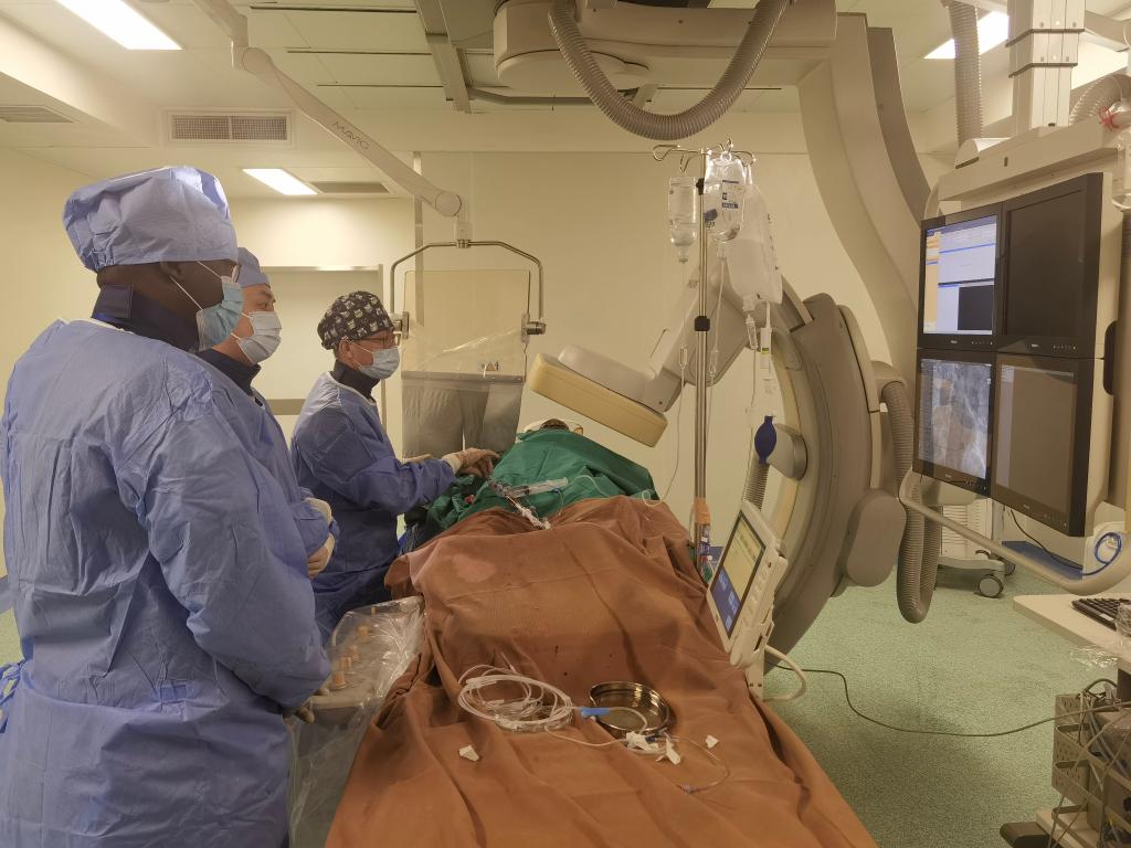 中國(guó)第29批援幾內(nèi)亞醫(yī)療隊(duì)隊(duì)員、首都醫(yī)科大學(xué)附屬北京天壇醫(yī)院心內(nèi)科副主任醫(yī)師王汝朋（右一）正在給患者做手術(shù)。（北京天壇醫(yī)院供圖）