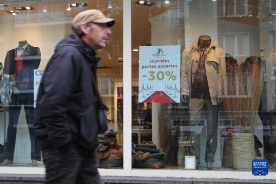   10月31日，一名男子從比利時布魯塞爾一家貼有打折信息的店鋪前走過。新華社記者 趙丁喆 攝