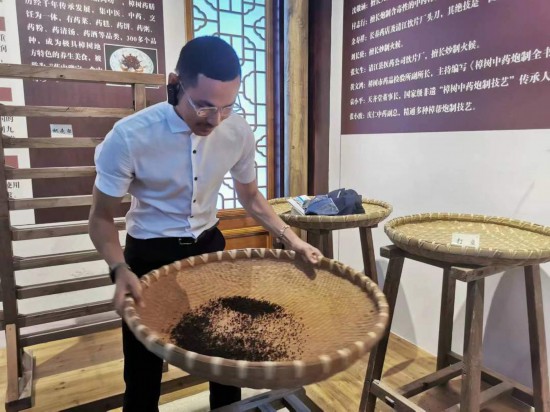 2023“一帶一路”媒體合作論壇聯(lián)合采訪團(tuán)團(tuán)員在非遺文化展示館體驗中藥炮制技藝。（本報記者 黃超攝）