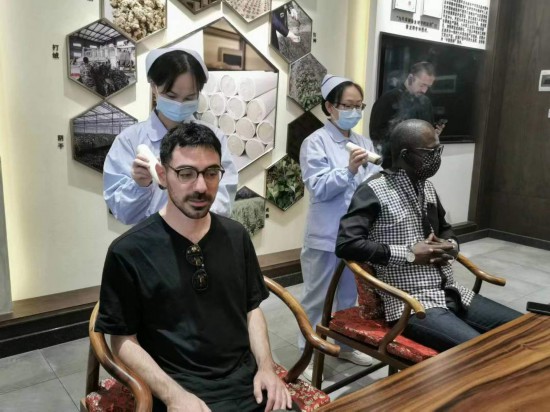 2023“一帶一路”媒體合作論壇聯(lián)合采訪團(tuán)團(tuán)員在九牛草展示館體驗艾灸。（本報記者 黃超攝）