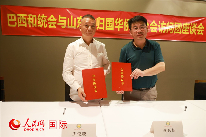 中國僑聯(lián)副主席、山東省僑聯(lián)主席李興鈺（右）與巴西和統(tǒng)會會長王俊曉簽署合作協(xié)議書。人民網(wǎng)記者 陳海琪攝