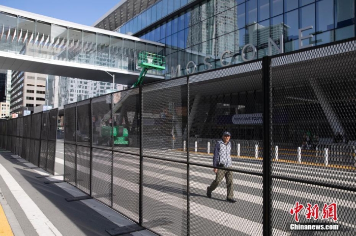 當?shù)貢r間11月10日，一名行人從美國舊金山莫斯康中心周圍的金屬圍欄旁經過。隨著亞太經合組織(APEC)第三十次領導人非正式會議臨近，作為會議場地的莫斯康中心附近出現(xiàn)金屬圍欄，執(zhí)勤警察也大幅增加。<a target='_blank' href='/'><p  align=