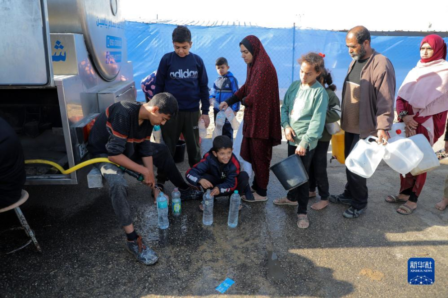 12月8日，在加沙地帶南部城市拉法一處臨時(shí)營(yíng)地內(nèi)，人們排隊(duì)打水。新華社發(fā)（里澤克·阿卜杜勒賈瓦德 攝）