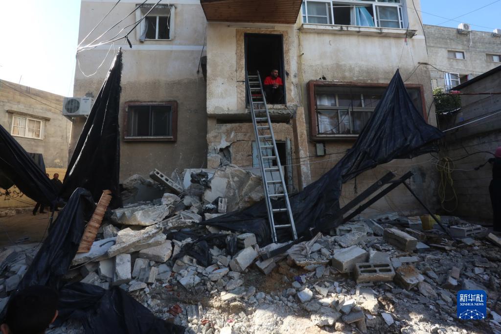 12月17日，在約旦河西岸城市圖勒凱爾姆附近的一處難民營，人們查看在沖突中損毀的房屋。新華社發(fā)（尼達爾·艾仕塔耶攝）