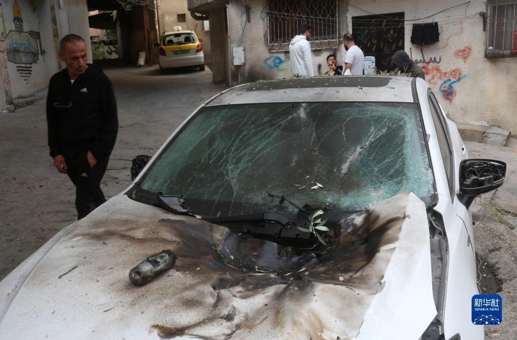 12月17日，在約旦河西岸城市圖勒凱爾姆附近的一處難民營，人們查看在沖突中損毀的車輛。新華社發(fā)（尼達爾·艾仕塔耶攝）