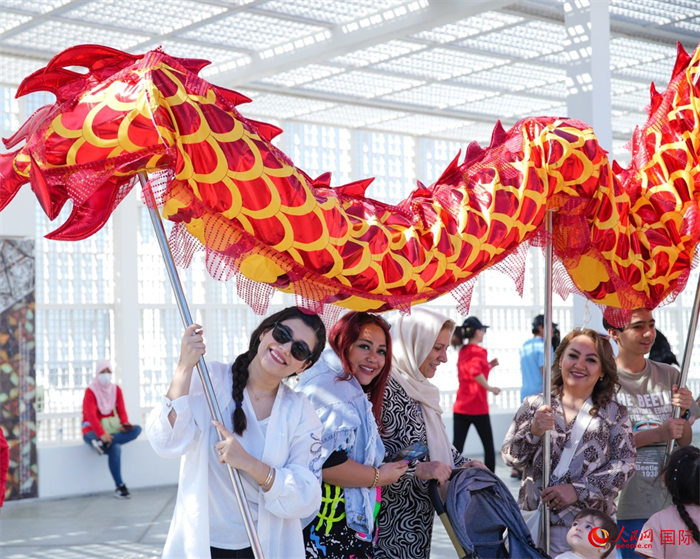 游客體驗(yàn)舞龍。 人民網(wǎng) 塔里克·易卜拉欣攝