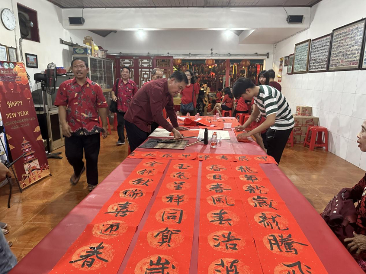 茍皓東為華人朋友現(xiàn)場(chǎng)寫春聯(lián)送福字。巴陵康孔子學(xué)院供圖