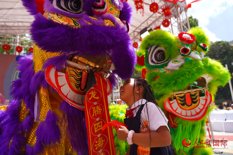 小朋友與舞獅表演者互動(dòng)。人民網(wǎng)記者 黃煒鑫攝