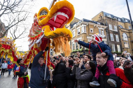 2月11日，人們在英國倫敦的新春巡游活動中觀看舞龍表演。新華社發(fā)（史蒂芬·程攝）