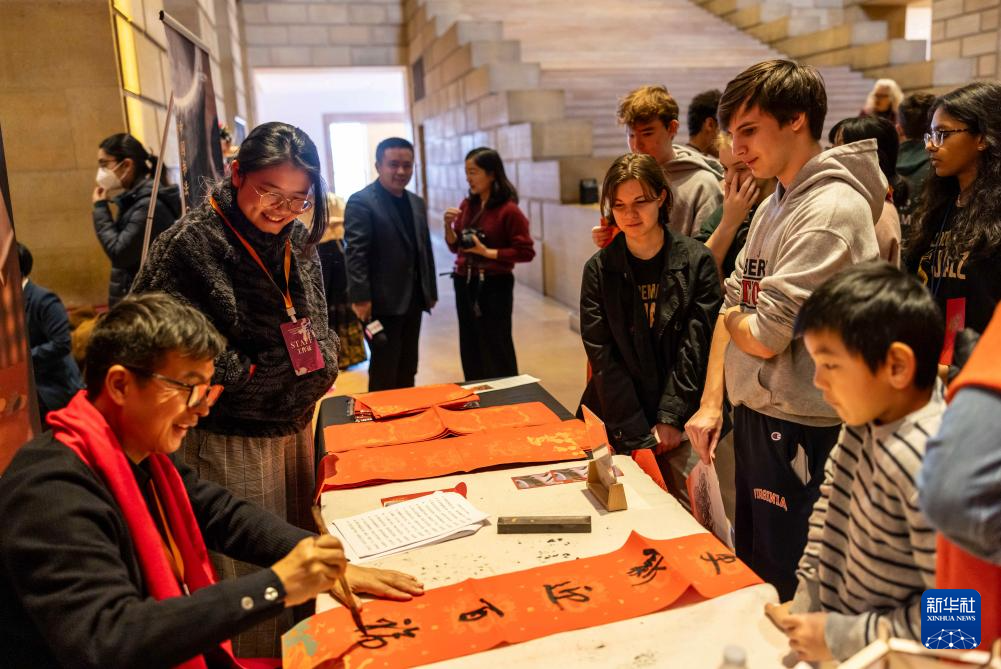 2月11日，書法家在美國費城藝術博物館舉行的龍年迎新春活動上為參觀者書寫對聯(lián)。新華社發(fā)（周煥新攝）