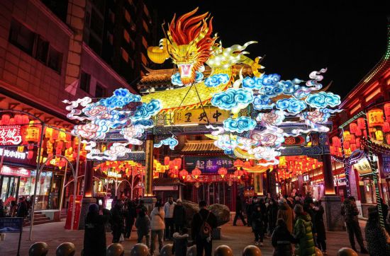 2月11日，游客在沈陽中街游覽。春節(jié)期間，各地?zé)艋痂病⒒饦溷y花，呈現(xiàn)出一幕幕流光溢彩的視覺盛宴。（新華社記者潘昱龍攝）