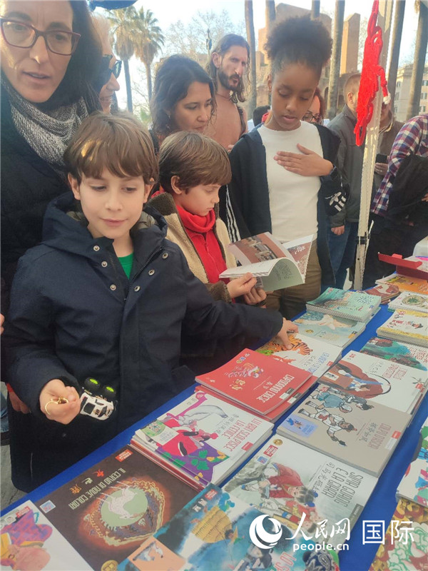 印刷精美的中國(guó)傳統(tǒng)文化叢書吸引了小游客的注意。人民網(wǎng)記者鄭彬攝