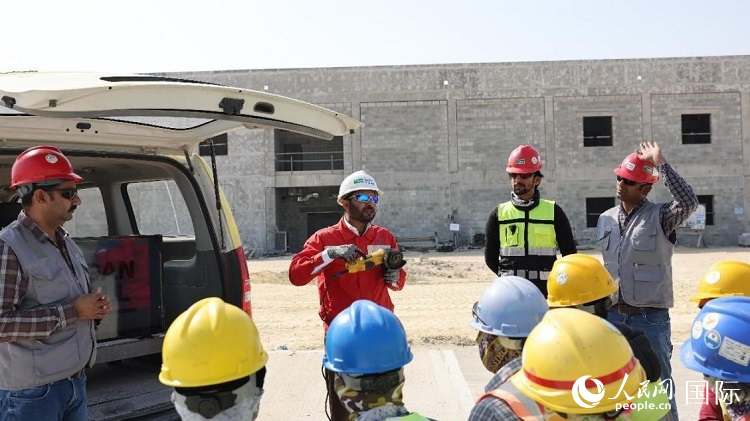 穆薩瓦爾(圖中紅衣人）現(xiàn)場(chǎng)演示工具操作規(guī)范。人民網(wǎng)記者 管克江攝