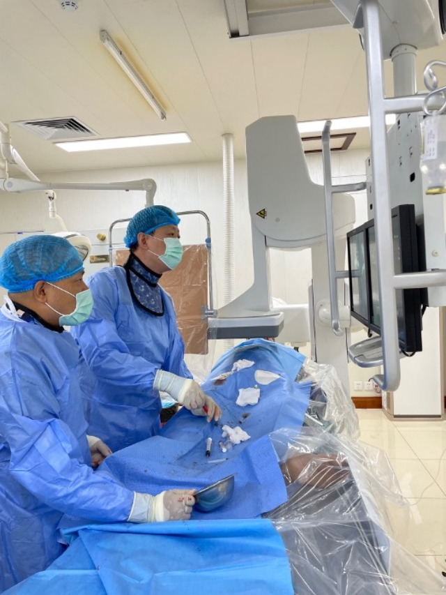 李凱教授（右）和劉海濤教授（左）為患者行TACE手術(shù)。中國駐老撾大使館供圖