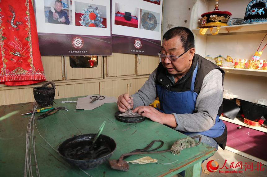 戲曲盔頭技藝傳承人許茂臣正在足活。 韓冰攝