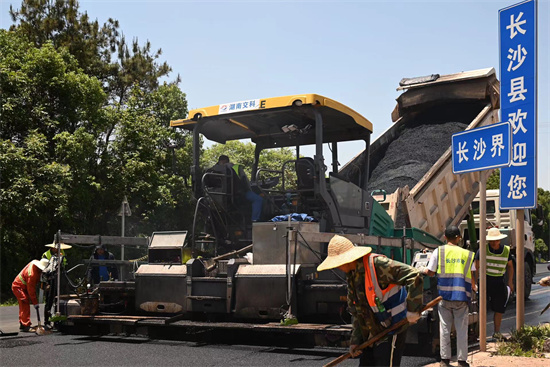 工人正在進(jìn)行“極薄磨耗層”路面的鋪筑。受訪單位供圖