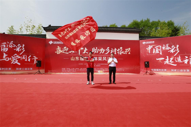 為媒體采風(fēng)團(tuán)授旗。 山東省福彩供圖