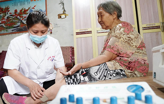 護(hù)理團隊醫(yī)生為老人進(jìn)行低頻功能康復(fù)。陳佳兵攝