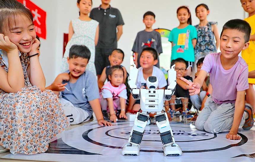 2022年7月19日，河北省秦皇島市海港區(qū)白塔嶺街道秦皇半島第二社區(qū)內(nèi)，小朋友正在觀看“機器人跳舞”。 曹建雄攝