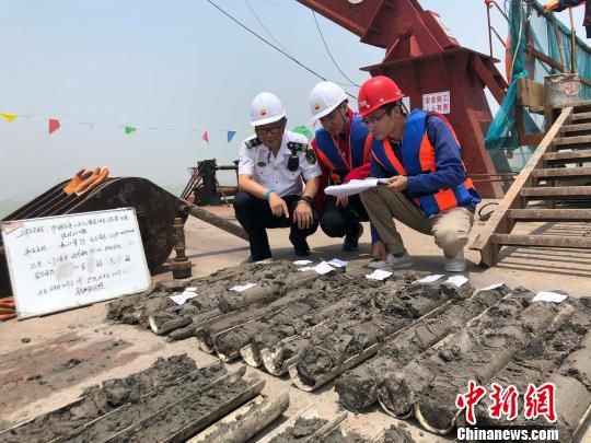 圖為勘察設(shè)計(jì)人員與海事局工作人員查看巖芯情況?！∥赫?攝